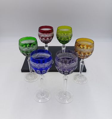 six verres à vin de couleurs différentes posés sur un plateau noir