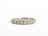 a close up of a diamond ring on a white surface