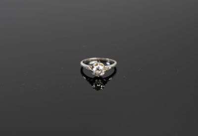 une vieille bague sertie d'un diamant taillé, posée sur une surface noire