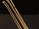 gros plan d'un collier en or sur une surface noire