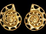 paire de boucles d'oreilles en or avec un motif en spirale sur fond noir