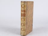 an old book sitting on top of a white surface