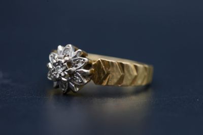 Gros plan sur une bague en or ornée d'une fleur