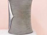 a close up of a vase on a white pedestal