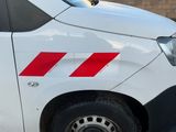 une camionnette blanche avec une bande rouge sur le côté