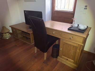 a desk with a computer and a chair in the room