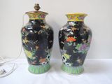 two vases sitting on a table with a lamp on top