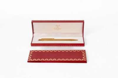 une boîte rouge contenant un stylo, posée sur une surface blanche