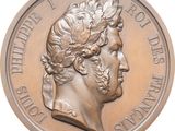 an image of a bronze medal with a man ' s face on it
