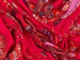 un gros plan sur une écharpe rouge et rose ornée de motifs paisley