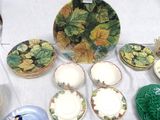 many plates and bowls on a table with a white table cloth