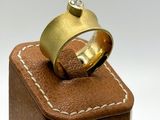 a gold ring with a diamond sitting on top of a wooden box