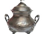 a large metal pot with a bird on it
