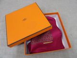 an orange box with a pink scarf inside of it on a table