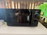 a microwave sitting on top of a table with a box on top of it