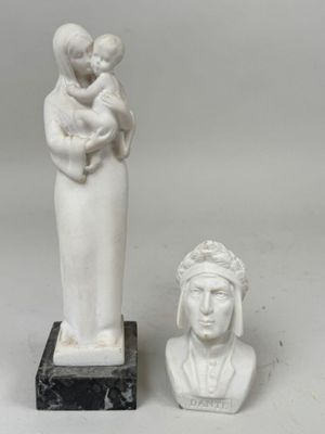 une statue représentant une femme tenant un bébé dans ses bras et un buste de femme