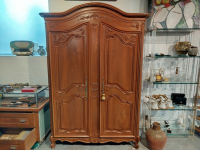 a wooden armoire in the corner of a room