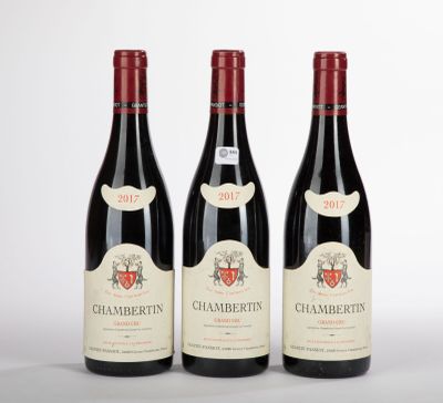 trois bouteilles de vin posées sur une table blanche