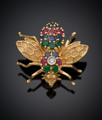un gros plan d'une broche en forme d'abeille en or, ornée de pierres multicolores