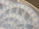 a blue and white plate with a spiral design on it