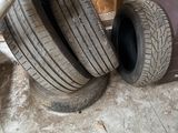 trois pneus sont empilés les uns sur les autres dans un garage