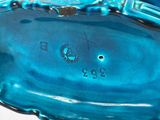 a blue glass vase with a black and white design on it