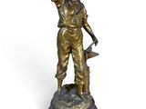 statue of a man with a hat on his head holding a hammer