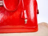 a red louis vuitton bag with a key in it