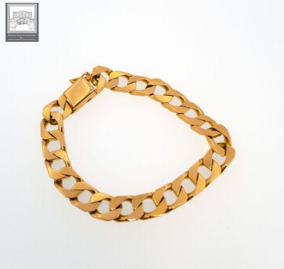 a gold bracelet with a curb link on a white background