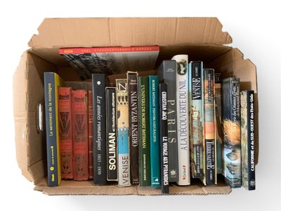 une boîte en carton remplie de livres posée sur une surface blanche