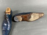 pair of blue leather shoes sitting on top of a gray surface