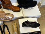 several pairs of shoes are lined up on boxes on the floor