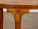 a round wooden table with a wooden top on a wooden floor