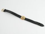 a close up of a black leather watch strap with a gold buckle