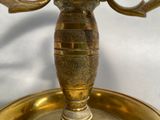 a gold plate with a brass candle holder on it
