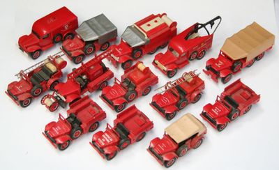 beaucoup de petits camions rouges en plastique sur une surface blanche