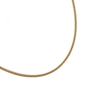 gros plan d'un collier en or sur fond blanc