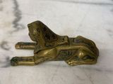 figurine en laiton représentant un chien couché sur une surface en marbre
