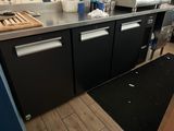 une photo d'une cuisine avec des placards noirs et des plans de travail en inox