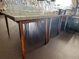 une longue table sur laquelle sont posés de nombreux verres, dans une pièce