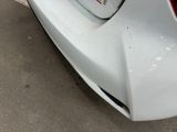a close up of a car ' s front bumper with a sticker on it