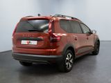 the rear of a red car is parked in a room