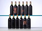 several bottles of wine sit on a glass shelf in front of a white wall