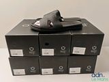 Plusieurs boîtes de chaussures noires sont empilées les unes sur les autres
