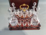 bottles and glasses on a wooden tray with a gold handle