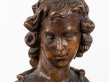 an antique bronze bust of a woman with curly hair