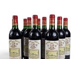 six bottles of wine are lined up on a white surface