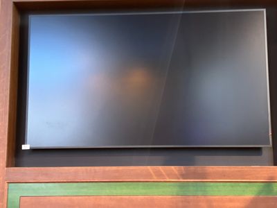 a flat screen tv sitting on top of a wooden entertainment center