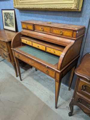 un bureau en bois avec un plateau vert et deux tiroirs