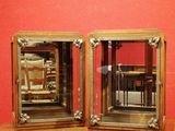 deux miroirs posés sur une table devant un mur rouge
